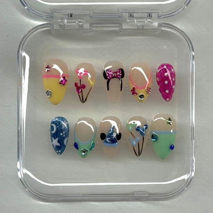 A playful Disney-inspired luxe set featuring glitter details, iconic silhouettes, pastel tones, bows, and whimsical mixed nail art