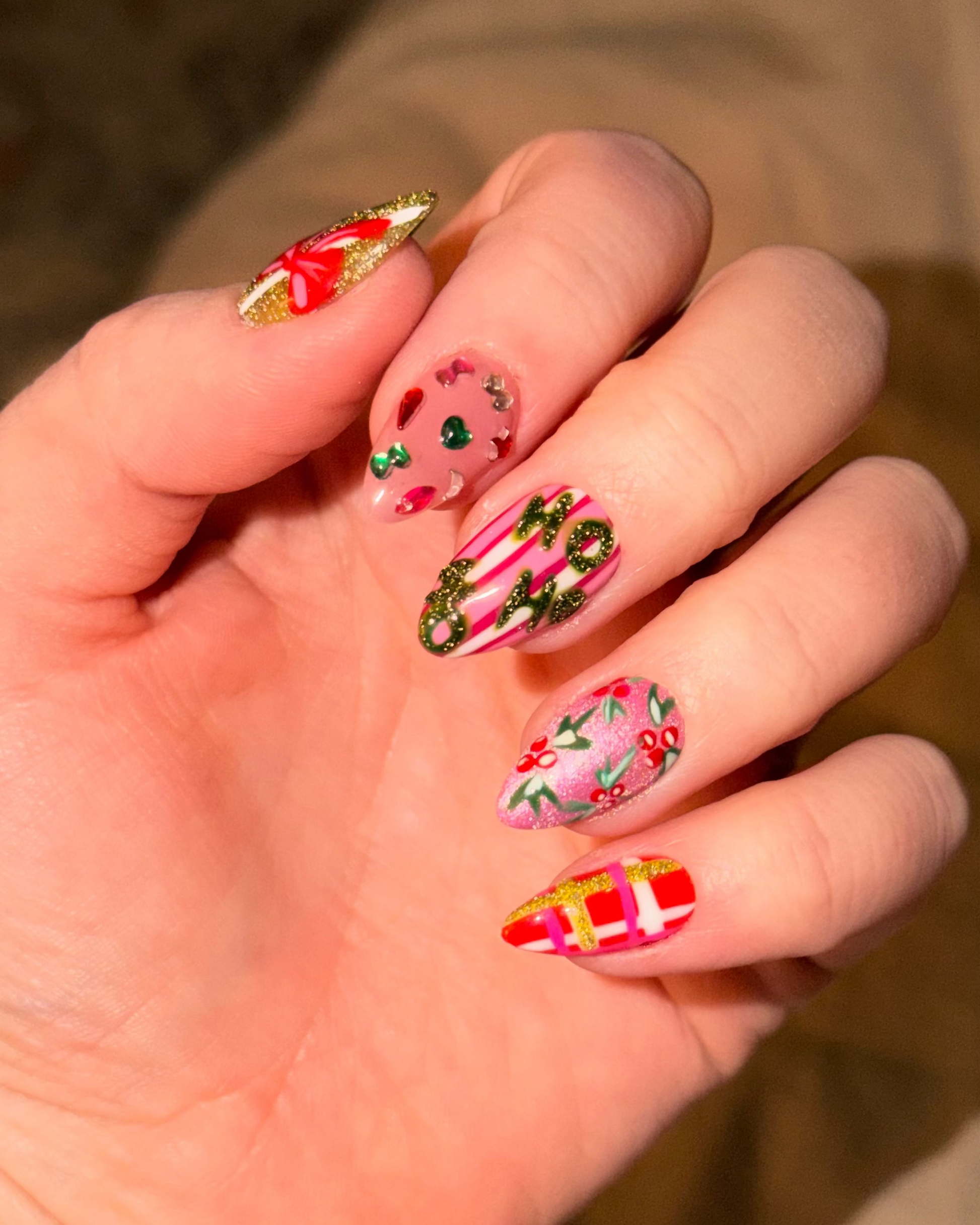 A luxe holiday set featuring glitter finishes, hand-painted ribbon details, festive jewel accents, and elevated Christmas-inspired nail art.